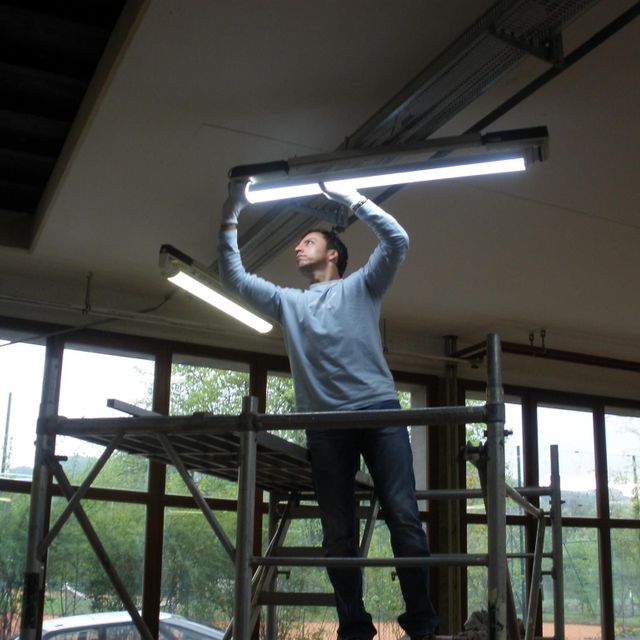 un homme installe des lampes